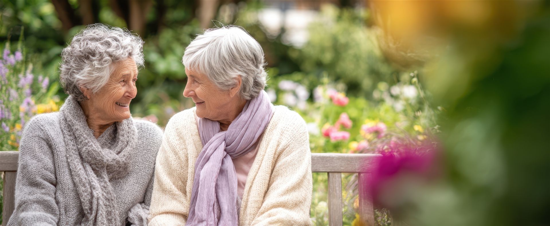 Rentnerinnen sitzen auf Bank im Garten